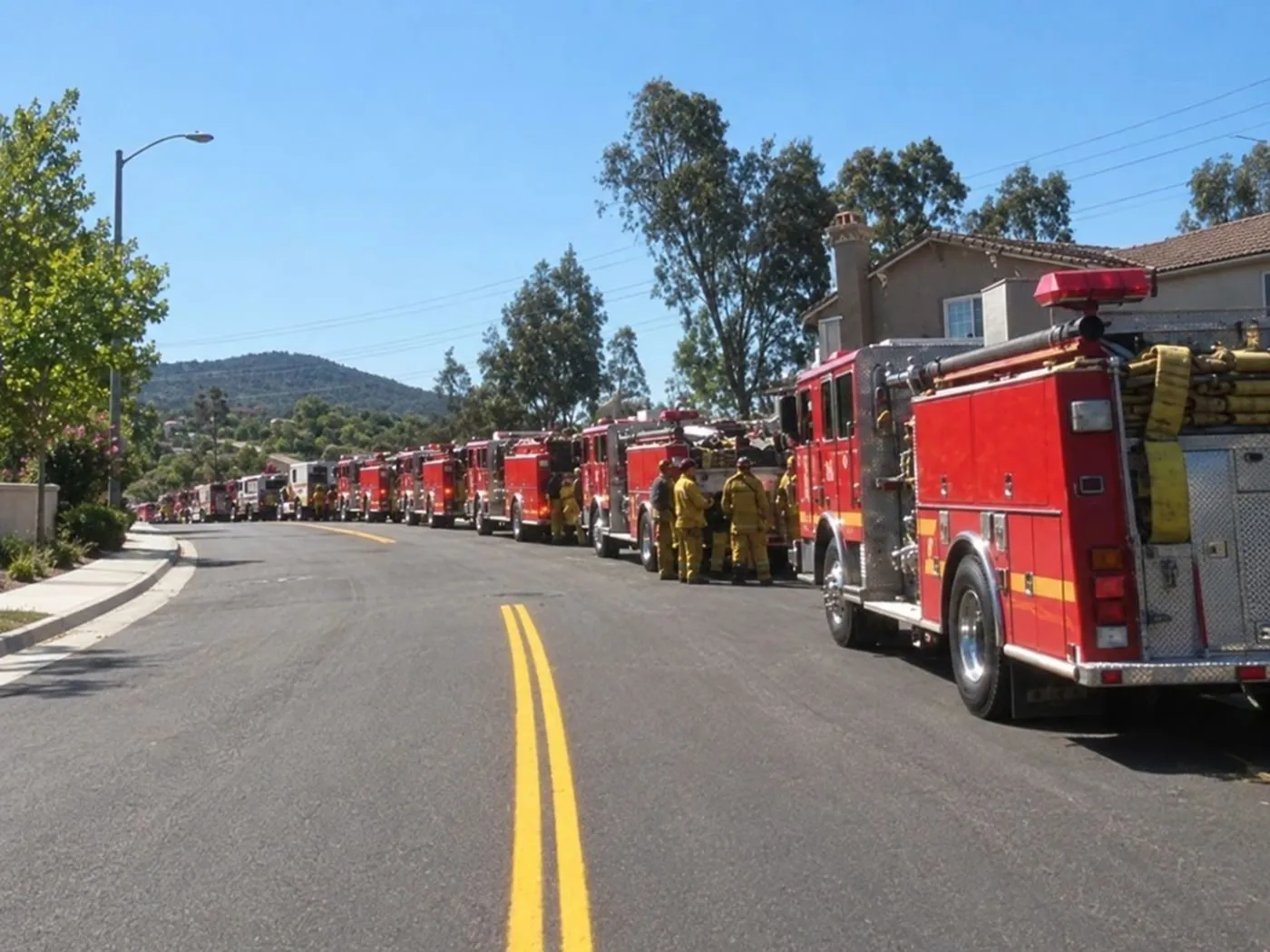 Fire engines lined up along a neighborhood street during a fire